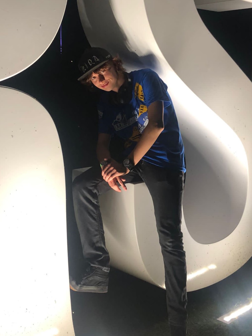 Sam Hobbelink sitting on the UT sign